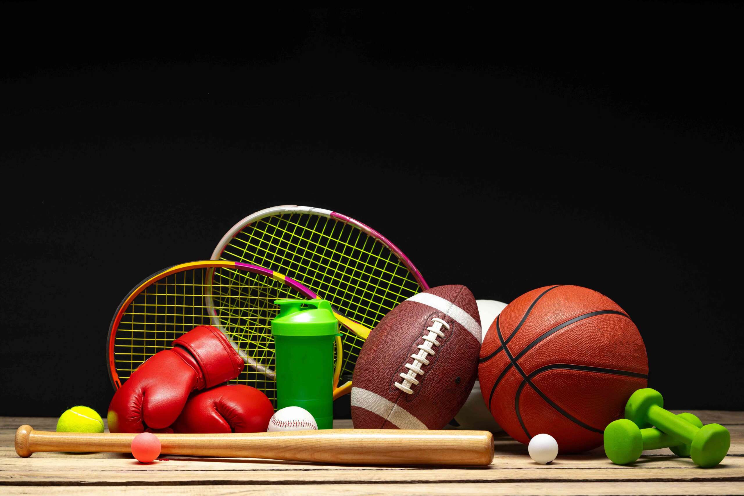 Various sports equipment on black background studio shot close up